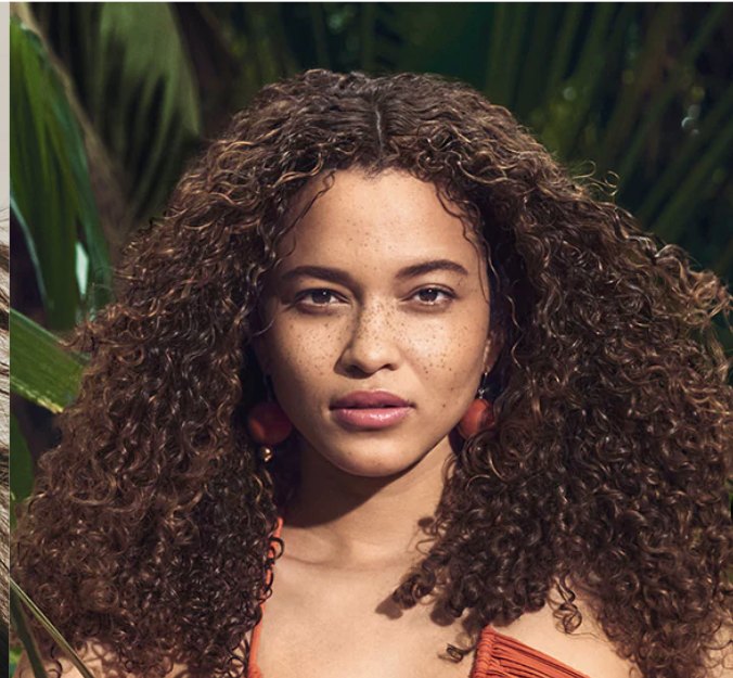 Aveda campaign portrait of a model with long curly hair