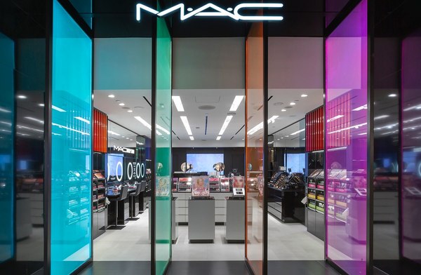 A MAC storefront with glowing colored glass panels and neon sign